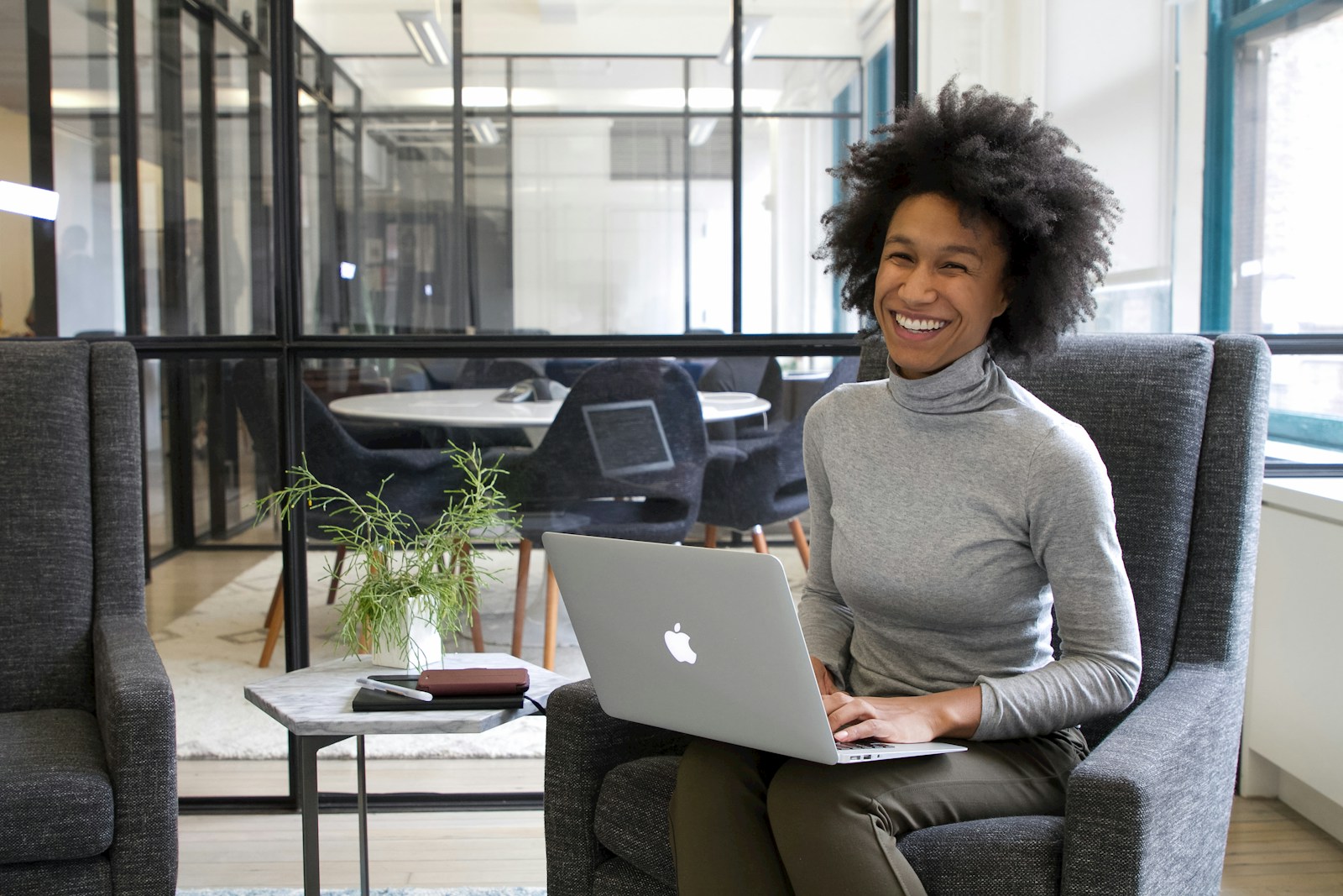 a woman sitting in a chair with a laptop a woman sitting in a chair with a laptop