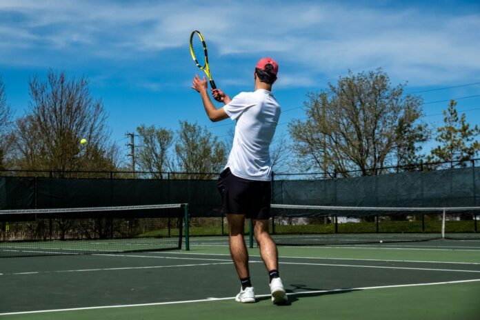 a man standing on a tennis court holding a racquet