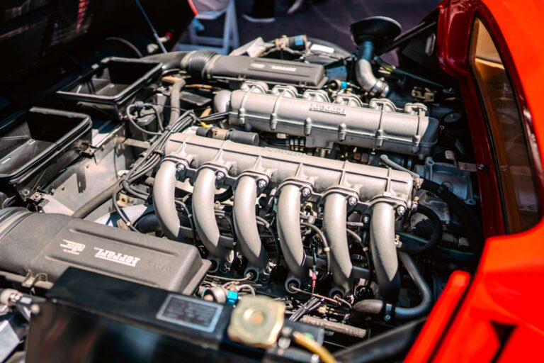 A close up of a car engine with its hood open