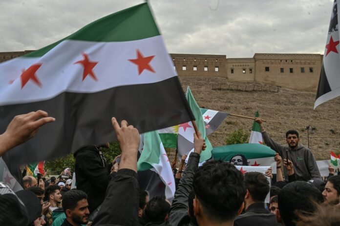 A group of people holding flags in front of a building