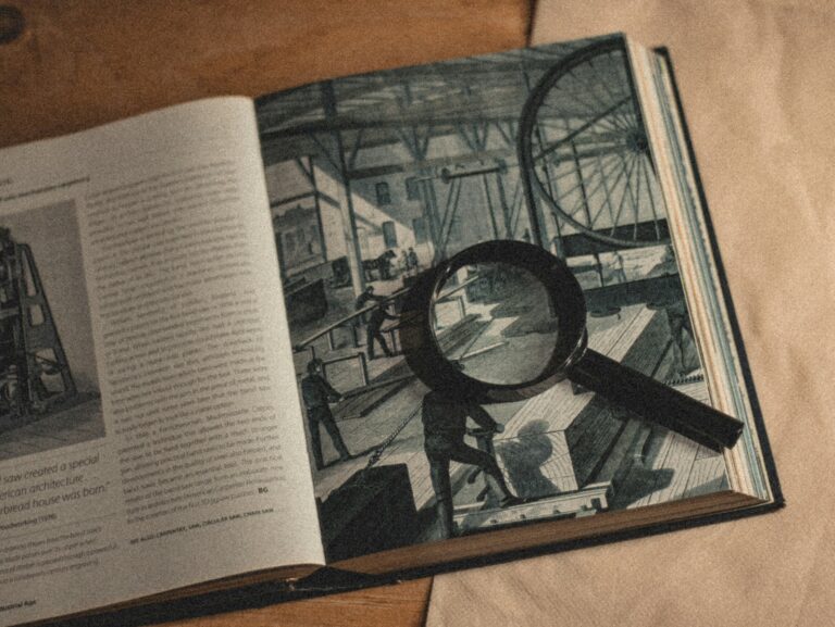 an open book with a magnifying glass on top of it