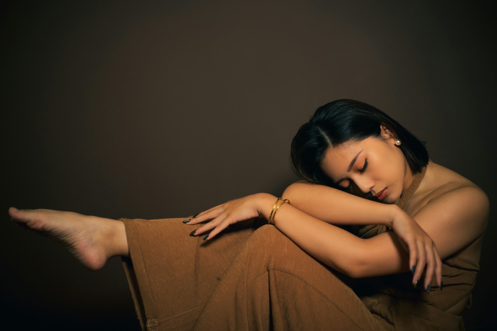 a woman sitting on the ground with her arms crossed - BDNF