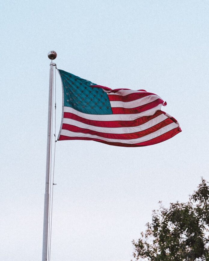 an american flag is flying in the wind